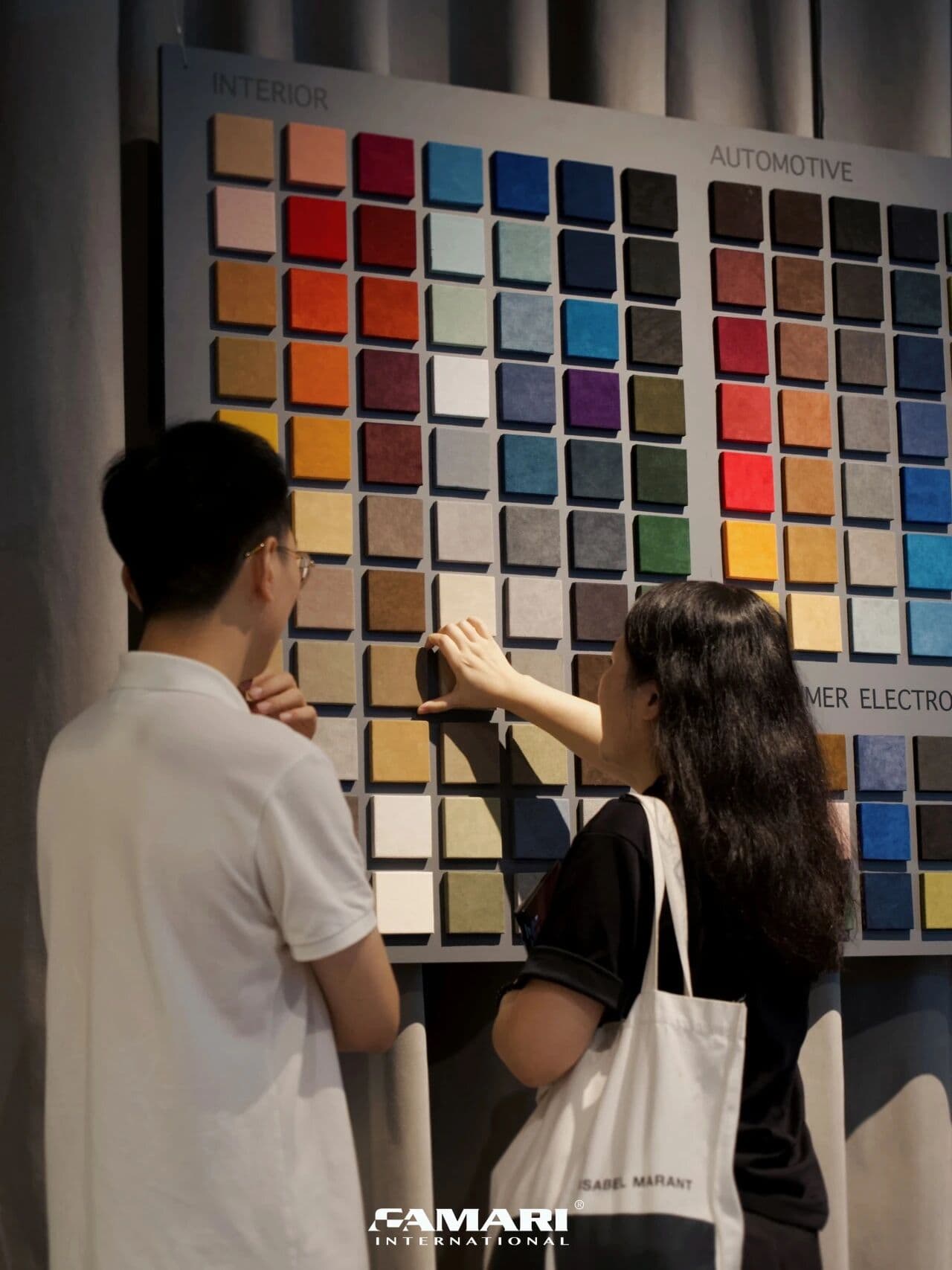 Visitors exploring Alcantara colour samples for interior and automotive applications