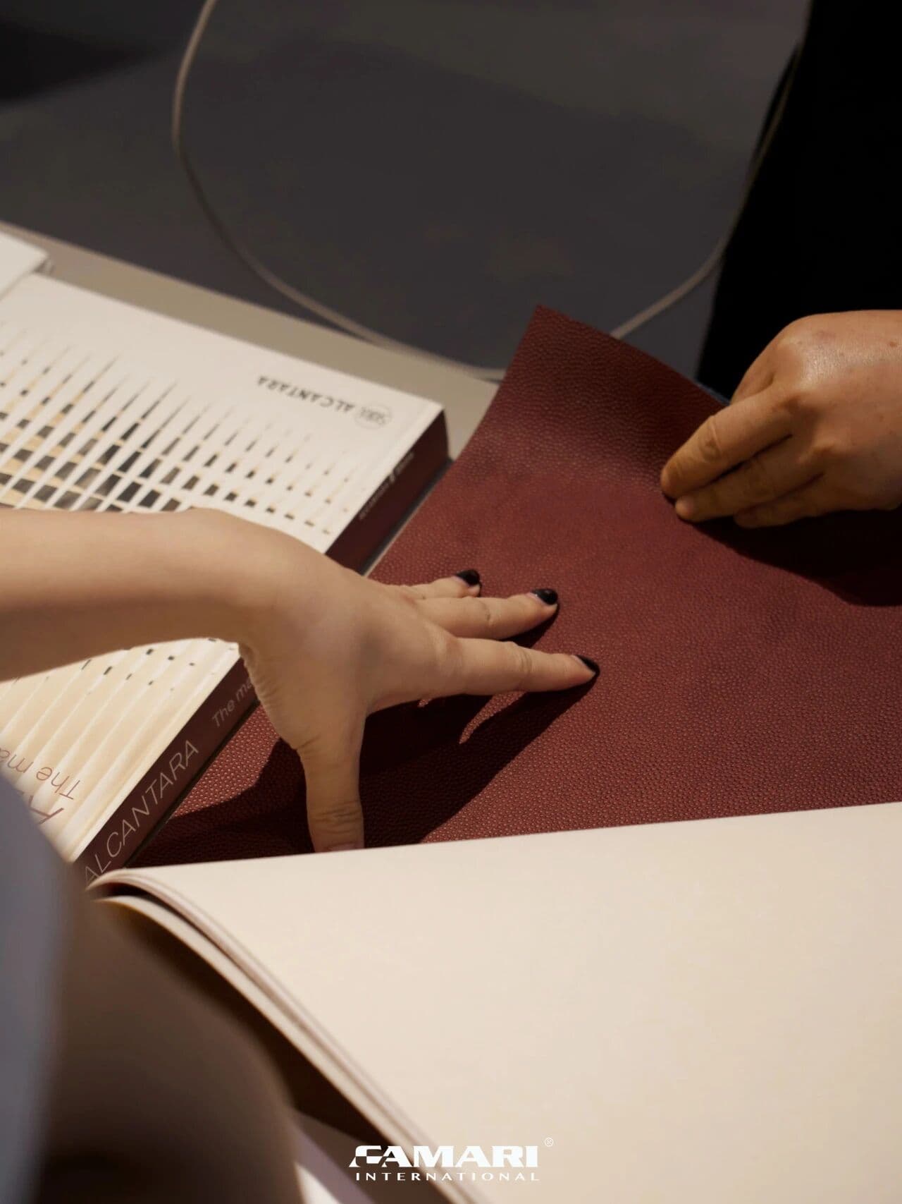 A visitor feeling the texture of an Alcantara sample at Design Shanghai